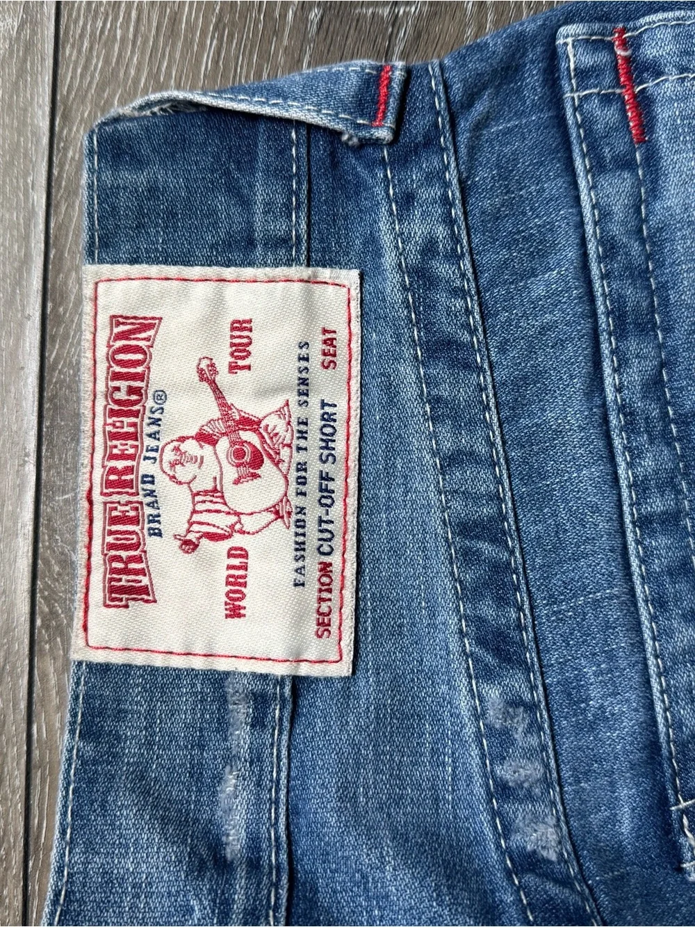 True Religion medium blue denim cutoff shorts with red logo patch